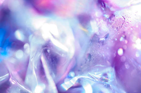 Holographic background in the style of the 80-90s. Real texture of cellophane film in bright acid...