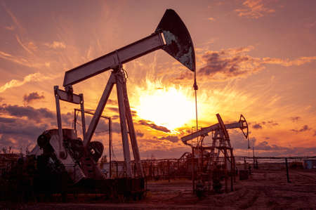 Oil pump rig. Oil and gas production. Oilfield site. Pump Jack are running. Drilling derricks for fossil fuels output and crude oil production. War on oil prices. Global coronavirus COVID 19 crisis.の写真素材