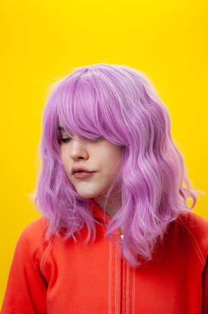 Close up fashion portrait beautiful young woman with pink hair on yellow background. Copy space.