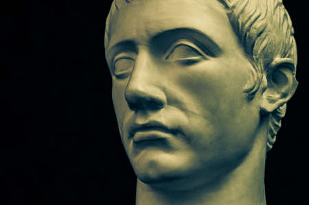 Bronze color gypsum copy of ancient statue of Germanicus Julius Caesar head for artists on black background. Renaissance epoch. Plaster sculpture of man face. Template for art designの写真素材