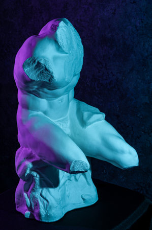 Gypsum copy of Belvedere Torso statue for artists. Replica of a famous ancient Greek fragmentary marble sculpture of male nude in color neon light. Template design for art, dj, fashion, poster, zine.の写真素材