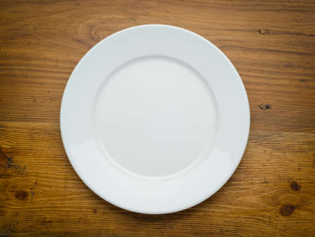 Empty white plate on wooden tableの写真素材