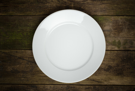 Empty white plate on old  wooden tableの写真素材