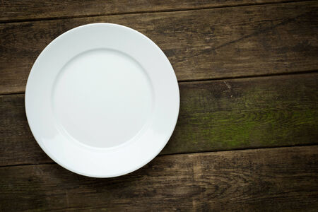 Empty white plate on wooden background close up の写真素材