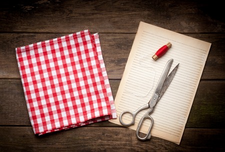 Sewing kit. Scissors, bobbins with thread and needles on the old backgroundの写真素材