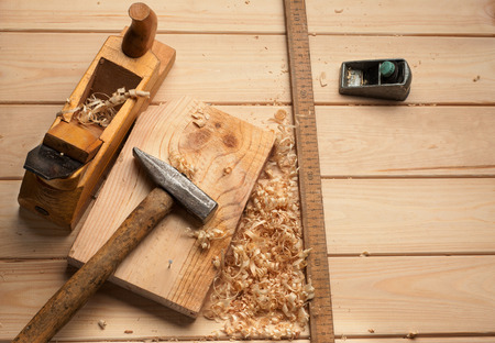 carpenter tools,hammer,meter, nails,shavings, and plane over wooden