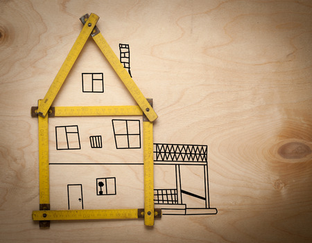 A house concept with yellow meter on wooden backgroundの写真素材