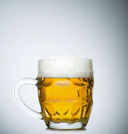Mug full of fresh beer isolated on white backgroundの写真素材