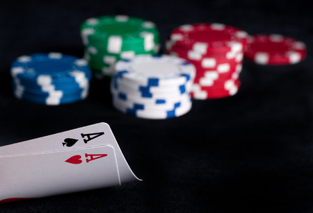 two aces high on black table with chips on black background