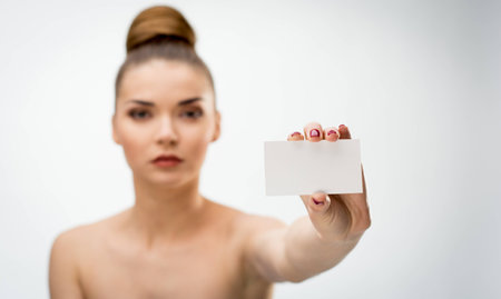 Beautiful woman holding a blank card on white backgroundの写真素材