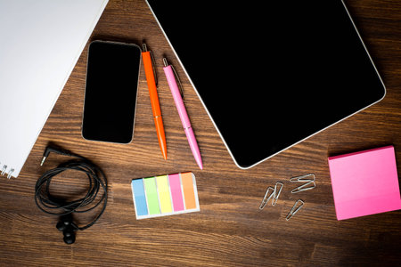 Digital tablet computer with note paper and cup of coffee on old wooden desk. Simple workspace or coffee break with web surfing.の写真素材