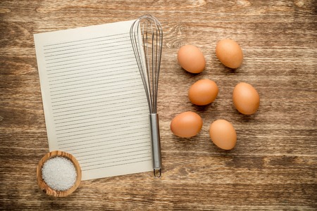 Eggs with beater and salt on wooden table.の写真素材