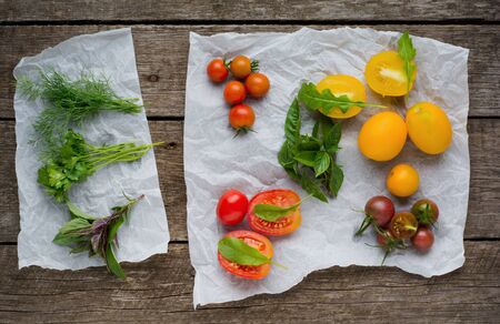 Fresh herbs and tomatos. Dill, basil and parsley tomaros  on rustic background.