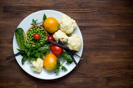 Photo of white plate with fresh vegetables. Top view.の写真素材