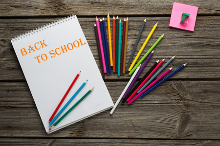 Back to School pupils art pencils and pad on wooden desk from above.の写真素材