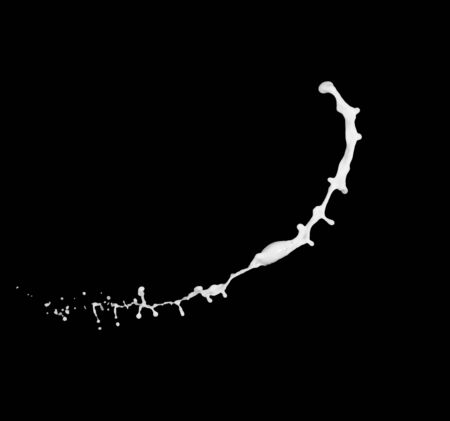 milk or white liquid splash isolated on black background.の写真素材