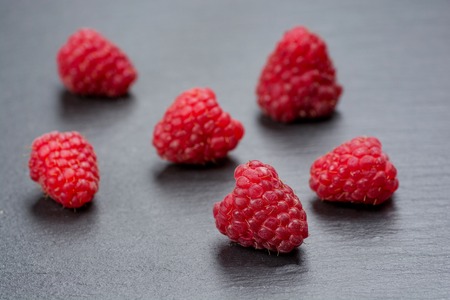 Fresh and tasty looking raspberries on a wooden table.の写真素材