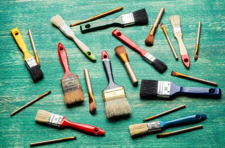 make up brushes and paint brushes sets over wooden board. top view .の写真素材