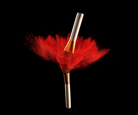 Make-up brush with powder explosion on black background.の写真素材