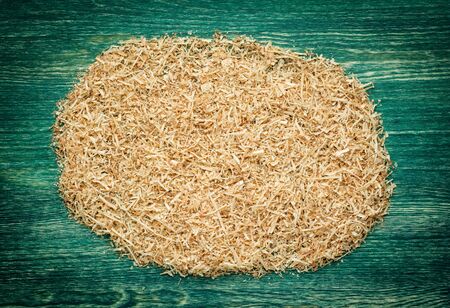 Thin, soft, twisted wood shavings on the green wooden background.の写真素材