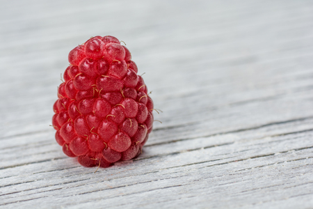 Raspberry fruit on light wooden background close up.の写真素材