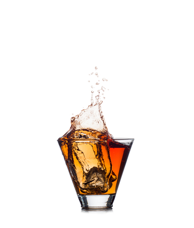 Whiskey splash out of glass isolated on white backgroundの写真素材
