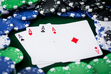 four kings on green background with poker chips.