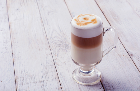 Delicious cappuccino on plank wooden table with copy spaceの写真素材