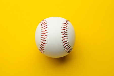 Baseball ball on yellow background with copy spaceの写真素材