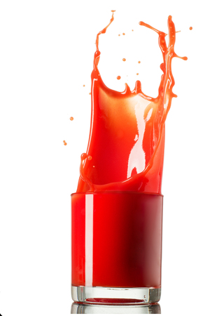 Glass of splashing tomato juice isolated on white. Tomato splash.の写真素材