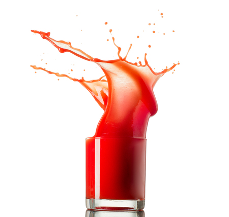 Glass of splashing tomato juice isolated on white. Tomato splash.の写真素材