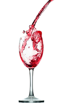 Pouring red wine in glass goblet isolated on whiteの写真素材