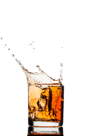 splash of whiskey with ice isolated on white backgroundの写真素材