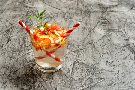 Cold refreshing summer lemonade in a glass on a grey concrete or stone background.の写真素材