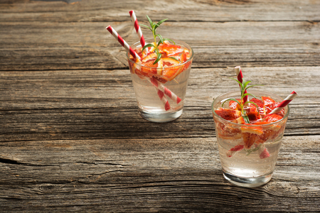 Summer fruit drinks. Fresh lemonade with oranges pieces on rustic wooden background.の写真素材