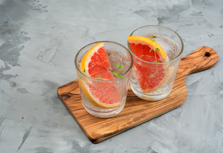 Cold refreshing summer lemonade in a glass on a grey concrete or stone backgroundの写真素材