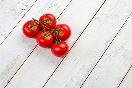 Fresh cherry tomatoes on rustic wooden backgroundの写真素材