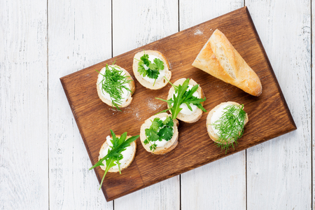 Tasty appetizer of Italian bruschetta with cheese and herbs on a rustic wooden background.の写真素材