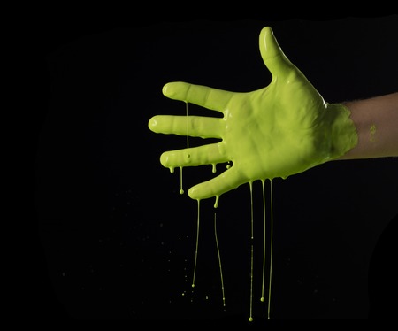 Elegant male hand on a light paint isolated on a black background.の写真素材