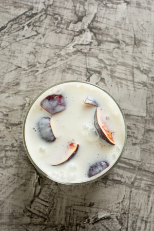 Fresh homemade yogurt in a glass with fig on concrete background. Tp view.の写真素材