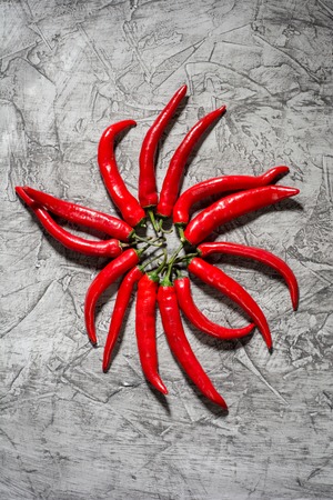 Red hot chili pepper pod close - up on grey concrete background. Selective focus and copy spaceの写真素材