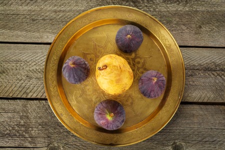 Group of figs with pear in a bowl on rustic wooden table. Top view. Flat lay.の写真素材