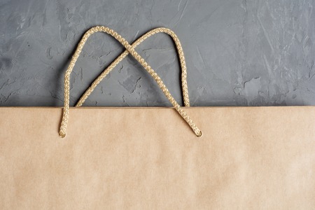 Sale and discount concept. Craft paper bag on concrete background with copy space. Flat layの写真素材