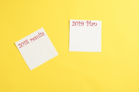 Make a goals list for 2018. Notebook near pen, glass and cup of coffee on grey wooden background top viewの写真素材