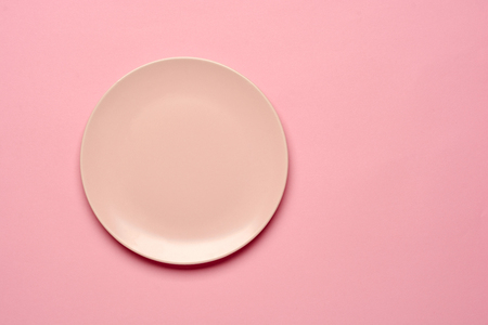 Round empty pink plate on pink background, top view or flat lay. Copy space.の写真素材