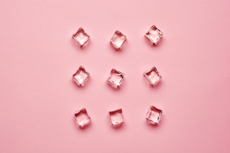 Set pieces of pure ice cubes on pink background with copy space. Top view or flat lay .の写真素材