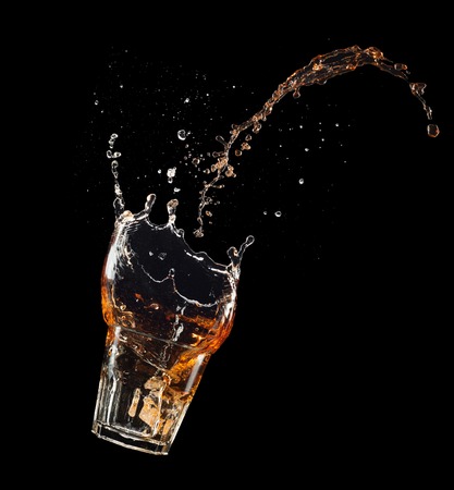 Isolated shot of whiskey with splash on black backgroundの写真素材