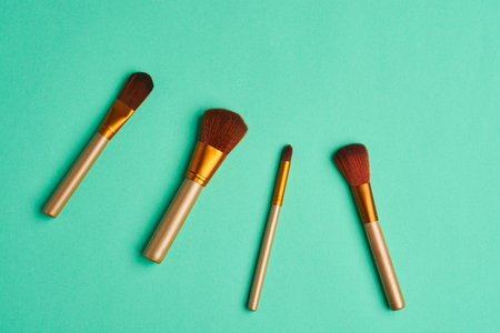 Fashion makeup brushes on a pastel turquoise background. Flat lay, top view.の写真素材