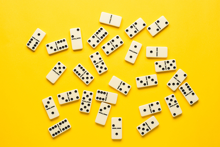 Domino pieces over bright yellow background, top view. Flat lay background.の写真素材