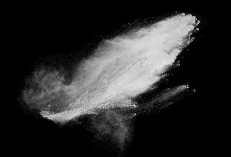 Freeze motion of white dust explosions isolated on black backgroundの写真素材
